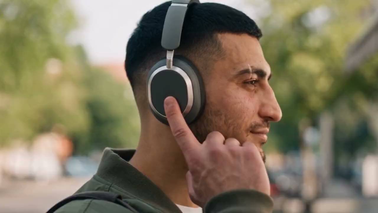 Ein Mann tippt an seinen Kopfhörer, danach trainiert er in einer Boxhalle im Gegenlicht